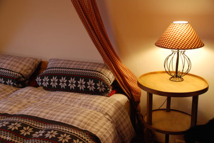 Bauernzimmer mit Nachttisch und rotkariertem Baldachin