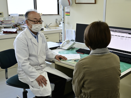 診察室で患者さんの話を聞く院長の様子