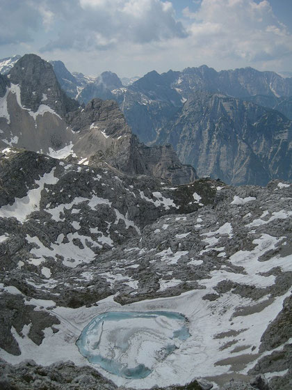 Der obere Krizsee mit der Pogacnik Hütte (rechts im Grünen) und dem Pihavec (links)