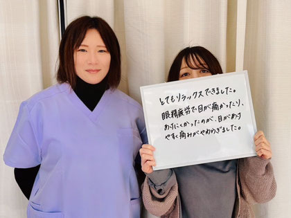 ご感想をホワイトボードに書いて持っているお客様と整体師1