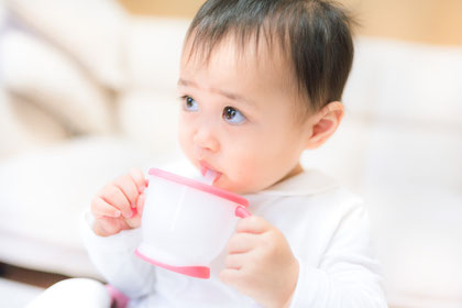 ベビーマグで飲む幼児の画像