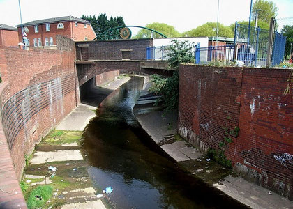 Photograph of the canalised River Rea near the site of Vaughtons Hole. The photograph was taken from Belgrave Middleway. The bridge carries Gooch Street.