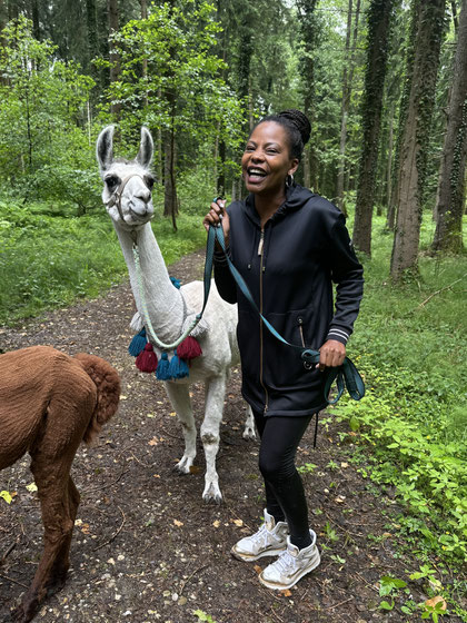 Glücklich strahlender Wandergast mit Lama Ole an der Hand.