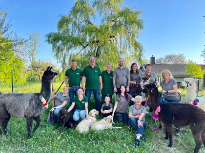 Gruppenfoto Team des Pointnerhofes, glückliche Mitarbeiter und zufriedene Alpakas und Lamas.