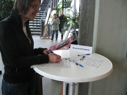(Foto: Besucherin beim Ausfüllen des Fragebogens)