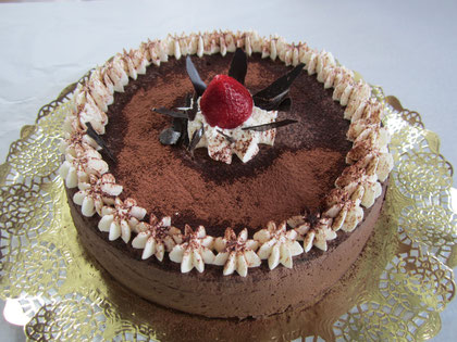 Tarta de mousse de chocolate decorada con nata, cacao y palitos de chocolate