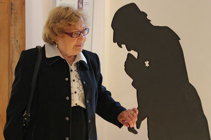 Paula Calder ergreift die Hand ihrer Mutter, die als Schattenriss dargestellt ist und dem Holocaust zum Opfer fiel.