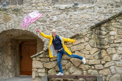 Katharina Wanha steht auf Bank mit Regenschirm