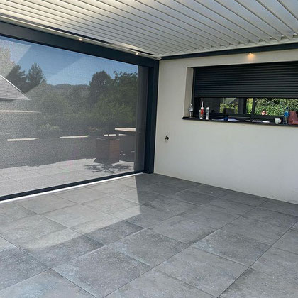 Une pergola bioclimatique posée sur une terrasse avec dalles sur plots. Les pergolas bioclimatiques sont plus imposantes qu'un store, et il faut accepter de voir l'apparence de sa maison modifiée mais, elles constituent une alternative très intéressante. 