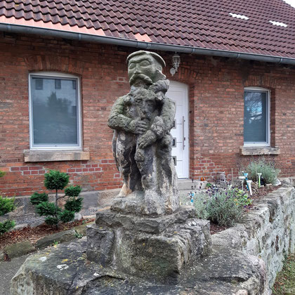 Hat er ein Dudelsack oder ähnliches in den Händen ?