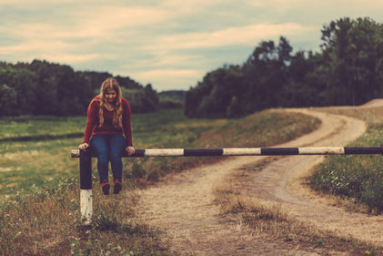 Girl balancing on barrier contemplating her goals