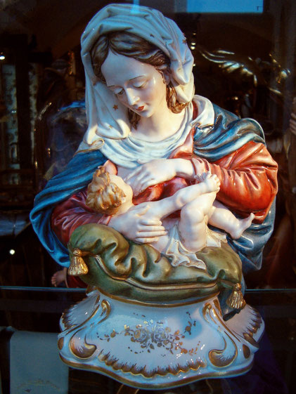 Maria stillt ihr Kind. Bild von einer Figur aus einem Schaufenster.