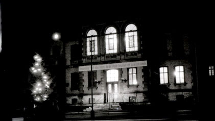 Am Rathaus in einem Ort in der frühereren DDR erkennt man ein Transparent mit den damals üblichen Parolen