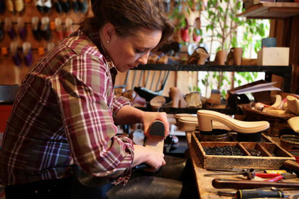 Cette image représente un maître artisan qui travaille le cuir dans son atelier