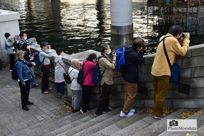 日本橋で講師のアドバイスを受けながら撮影する受講生