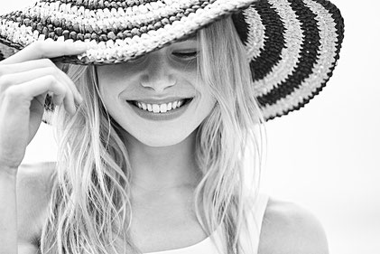 Mujer con sombrero playero sonriente