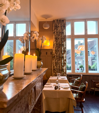 Der Saal des Düsseldorfer Italiener, Ristorante La Volpe, mit eingedeckten Tischen mit Tischdecke, Kamin, Kerzen und großem Spiegel
