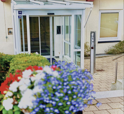 Kleiner Fitnessraum mit Heimtrainer, Laufband, Hantelbank und Spiegel an der Wand