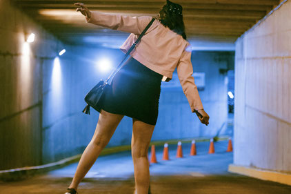 femme en équilibre entre deux voies dans un parking souterrain