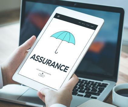 Mains d'homme blanc tenant une tablette, sur l'écran de laquelle est figurée un parapluie bleu clair avec la mention "assurance" en dessous.