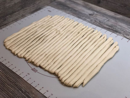 Glasbehälter mit Hefeteig auf Holztisch stehend