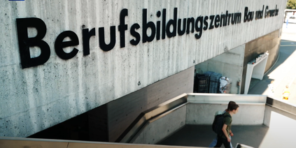 Luca Birrer und eine Kollegin auf der Treppe zum Berufsbildungszentrum Bau und Gewerbe in Luzern.