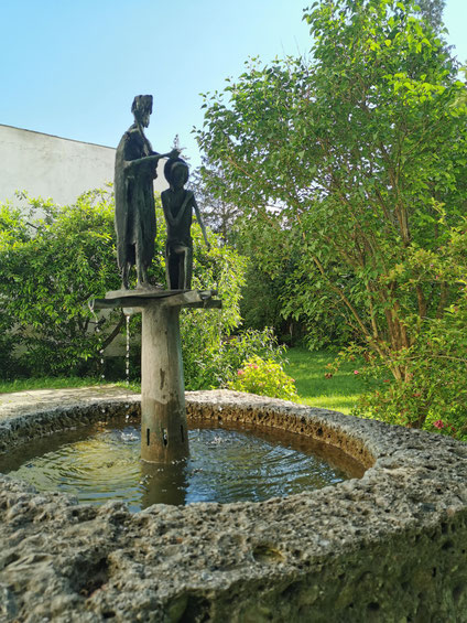 Künstlerische Darstellung der Taufe Jesu auf einem Brunnen