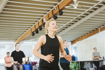 Trainerin hält eine Fitnesskurs-Stunde