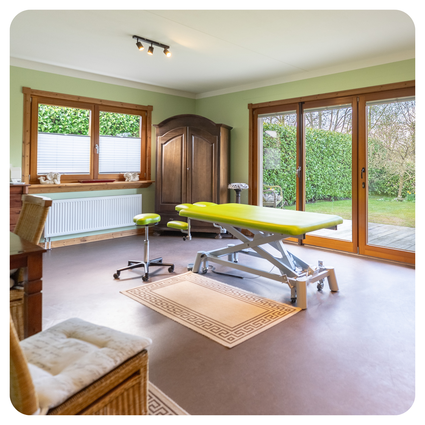 Behandlungsraum der Physiotherapie Musterbruch am Standort Nordhastedt mit Therapieliege und Gartenblick