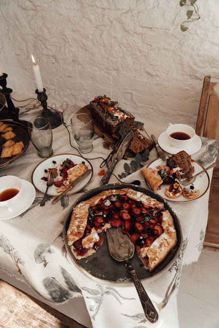 Tee und Beerenkuchen auf einer mittelalterlich anmutenden Tafel. Bild von furkanfdemir aud Pexels.