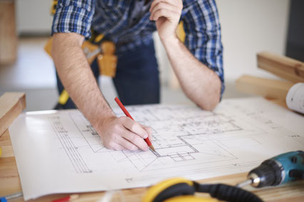 Bild: Freepik, worker-with-amendments-on-blueprint-of-house