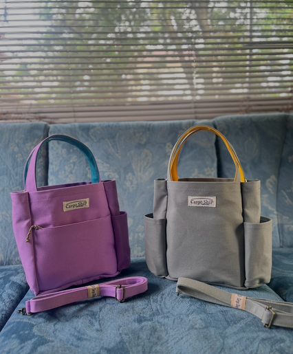 ワンちゃんのお散歩バッグとして販売している、Cargo Shipの帆布ドッグバッグ。ラベンダーとターコイズのバッグに、ライトグレーとヒマワリカラーのドッグバッグが2つ並んでいます