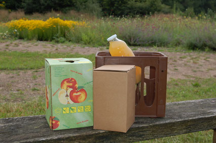 Das Bild zeigt die verschiedenen Abfüllbehälter, die unsere Mosterei anbietet. Eine 5 Liter "Bag in Box", eine 3 Liter "Bag in Box" und eine Kiste, mit einer gefüllten Apfelsaftflasche.