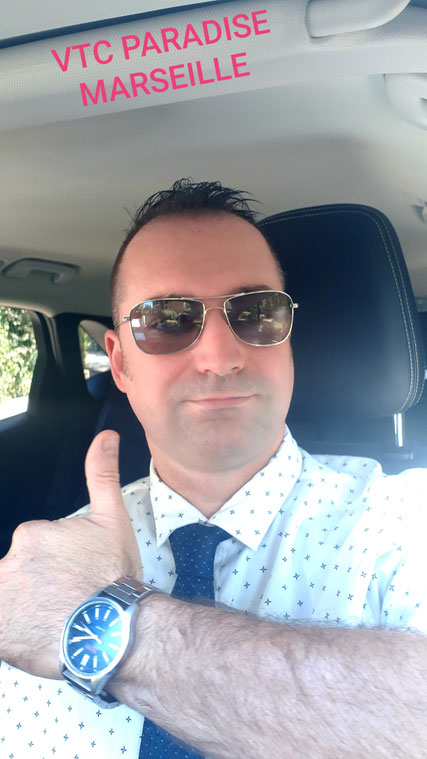 Chauffeur privé Marseille souriant pouce en l'air très classe chemise cravate 