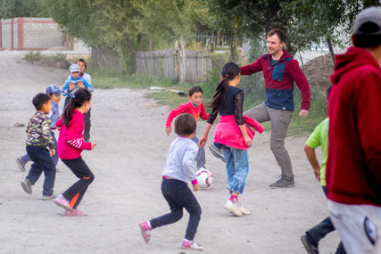 Bastian playing football in the streets of Kara-Kool