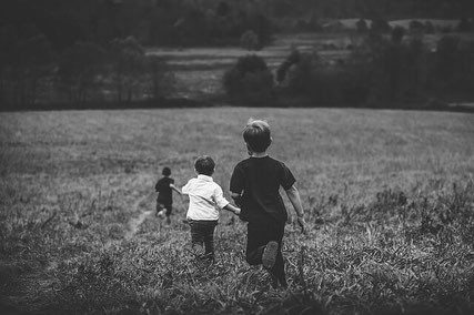 Happy boys running in field.