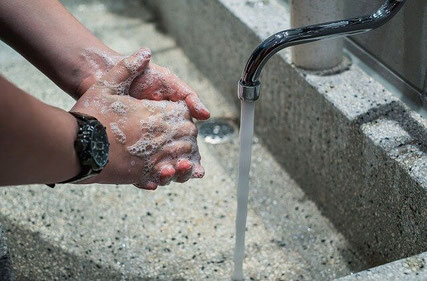 Washing hands with soap.