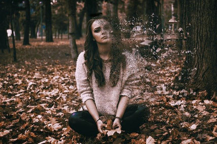 Sad woman in forest.