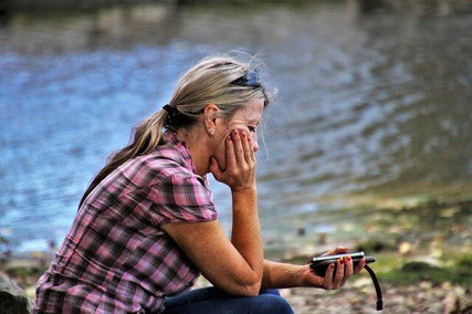 Sad woman by lake.