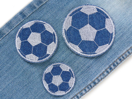 !B Fußball Bügelflicken aus Jeansstoff sind als Flicken auf eine Jeanshose aufgebügelt 