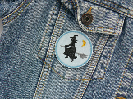 Patch zum aufbügeln mit einer kleinen gestickten schwarzen Hexe als Accessoire für eine Jeansjacke