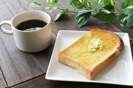 バターがたっぷりのトーストがのったお皿。コーヒーの入ったマグカップ。