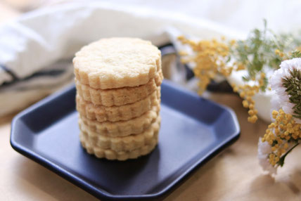 お皿のうえに積まれたクッキー。ドライフラワーとキッチンクロス。