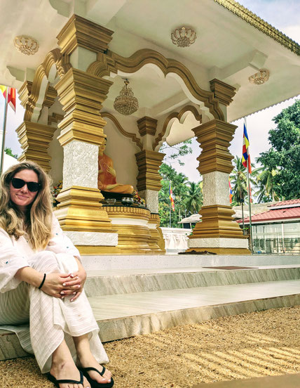 This is me sitting in a very peaceful corner on the compound. In the background: One Buddha Shrine.