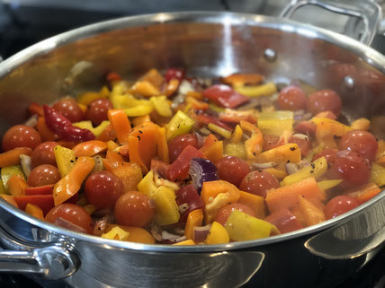 Edelstahlpfanne mit Gemüse auf dem Herd