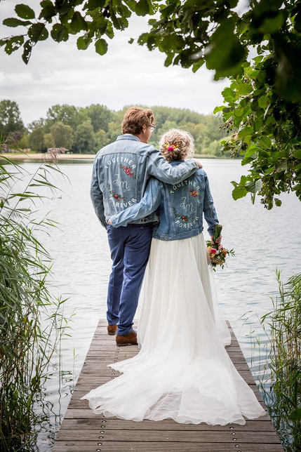 bruidspaar beiden in dezelfde handbeschilderde spijkerjasjes