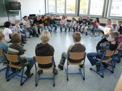 Pit Budde macht mit einer Klasse erst ein paar musikalische Übungen, um dann später das jeweilige KLassenlied einzuüben.