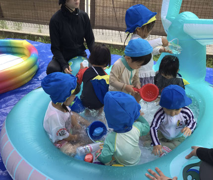 「くじらのプール、はいる！」「水、いっぱい入れたよ！」と、みんなカップに水をいれたり、浮かんでいるおもちゃを捕まえたりして楽しそうに遊んでいました。