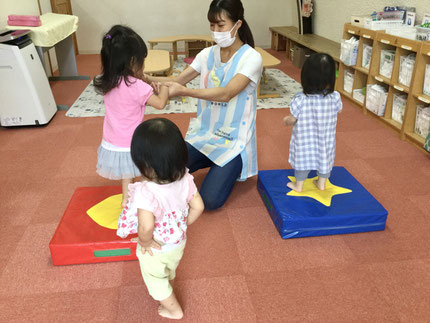 今日は午前中、雨が降っていたので室内遊びを楽しみました。そらぐみさん、ひかりぐみさんはジャンプマットと、ウレタンの階段で遊びました。先生に手を繋いでもらい、ピョンピョンとジャンプを楽しむ子もいれば、膝を曲げて自分で跳ねている感覚を楽しんでいる子もいました。