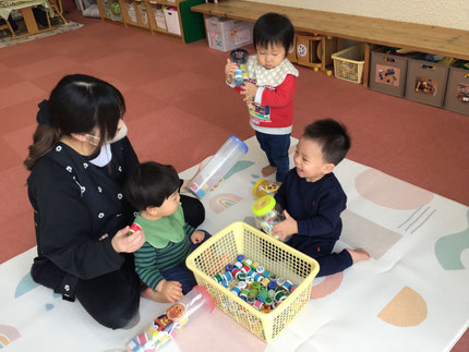 今日は、保育園今年最後の1日でした。そらぐみさんはポットン落としで遊びました。色々な絵の書いてあるペットボトルのキャップを穴の中に入れて遊びました。たくさん入れて、いっぱいになった入れ物をうれしそうにガラガラと振っていました！